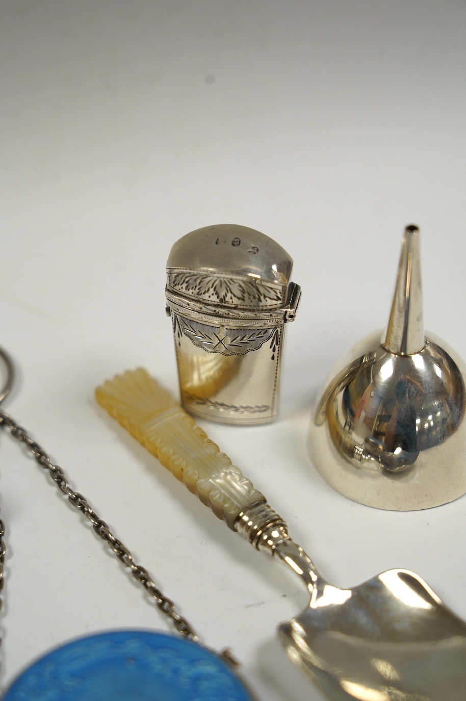 Five assorted small silver items including an early 19th century silver scent bottle case by Samuel Pemberton, containing a small glass flask, a mother of pearl handled caddy spoon, a silver whistle, a small funnel and a